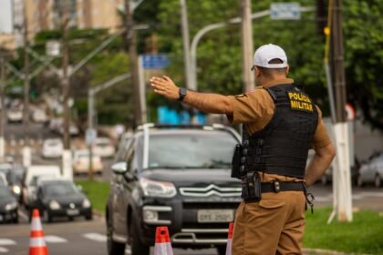 Police officer directing traffic on a busy street in Londrina, Brazil.