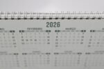 Close-up of a 2026 spiral-bound desk calendar with months in Portuguese.