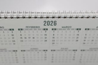 Close-up of a 2026 spiral-bound desk calendar with months in Portuguese.