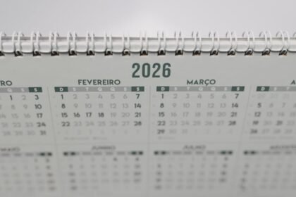 Close-up of a 2026 spiral-bound desk calendar with months in Portuguese.